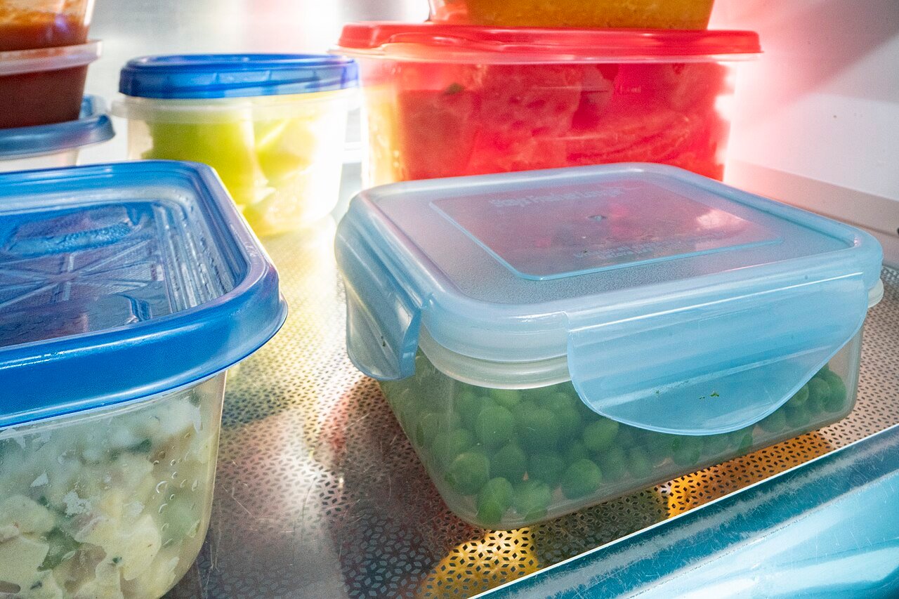 Food leftovers in sealed clear containers inside a refrigerator