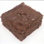 Square chocolate brownie on a plate, reference image for fudgy cocoa brownies