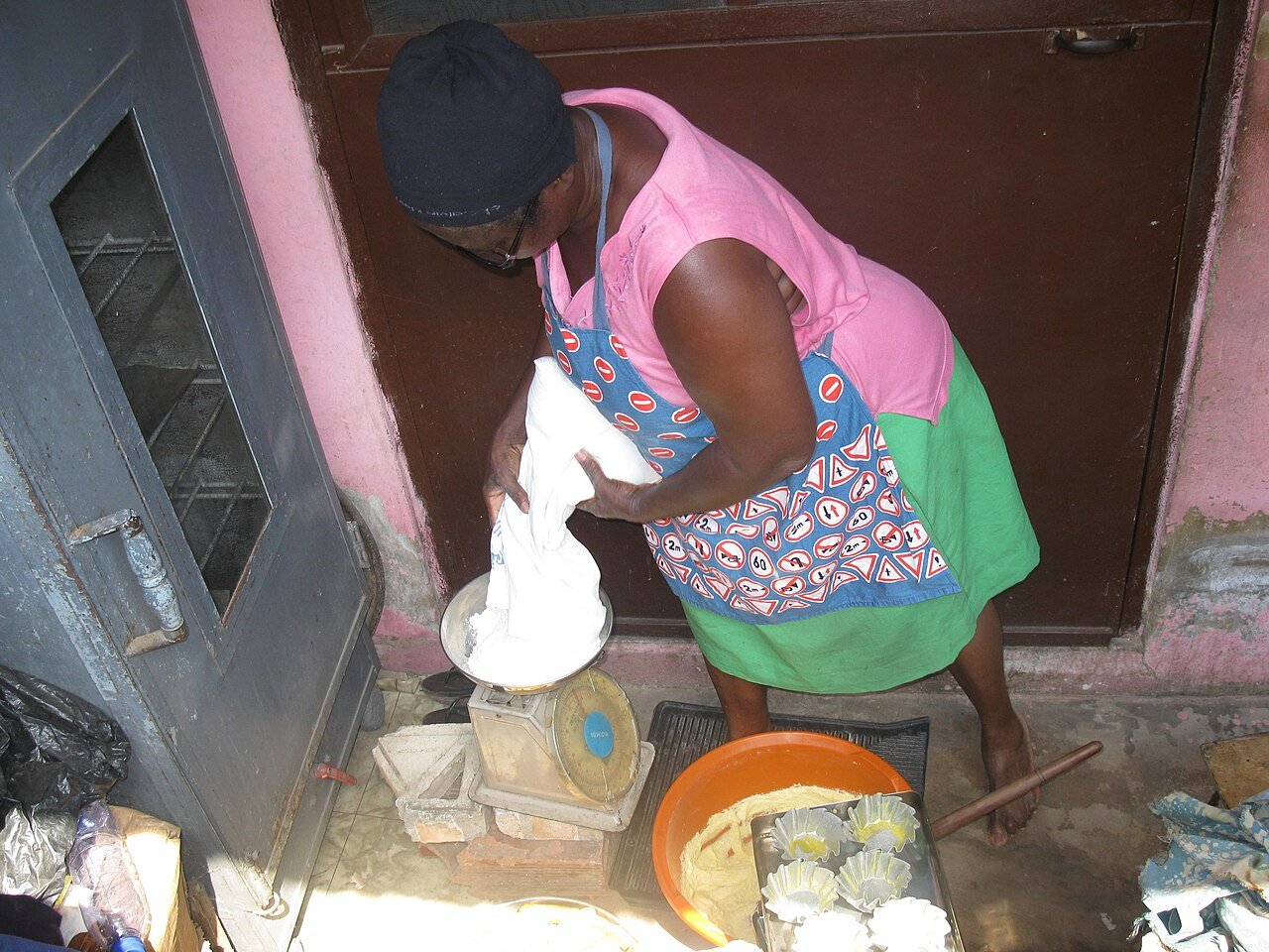 Baker measuring flour while preparing baked goods
