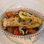 Baked salmon on mixed vegetables on a plate