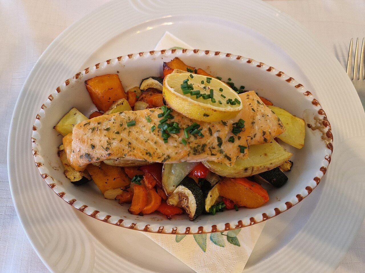 Baked salmon on mixed vegetables on a plate